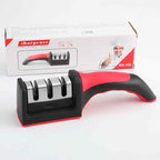 Knife sharpener with red and black handle in front of its packaging on a white background