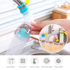 Hand holding a water filter attachment with water flowing, set against a kitchen sink background.
