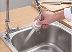 Person using a kitchen faucet with a handheld sprayer attachment over a sink.