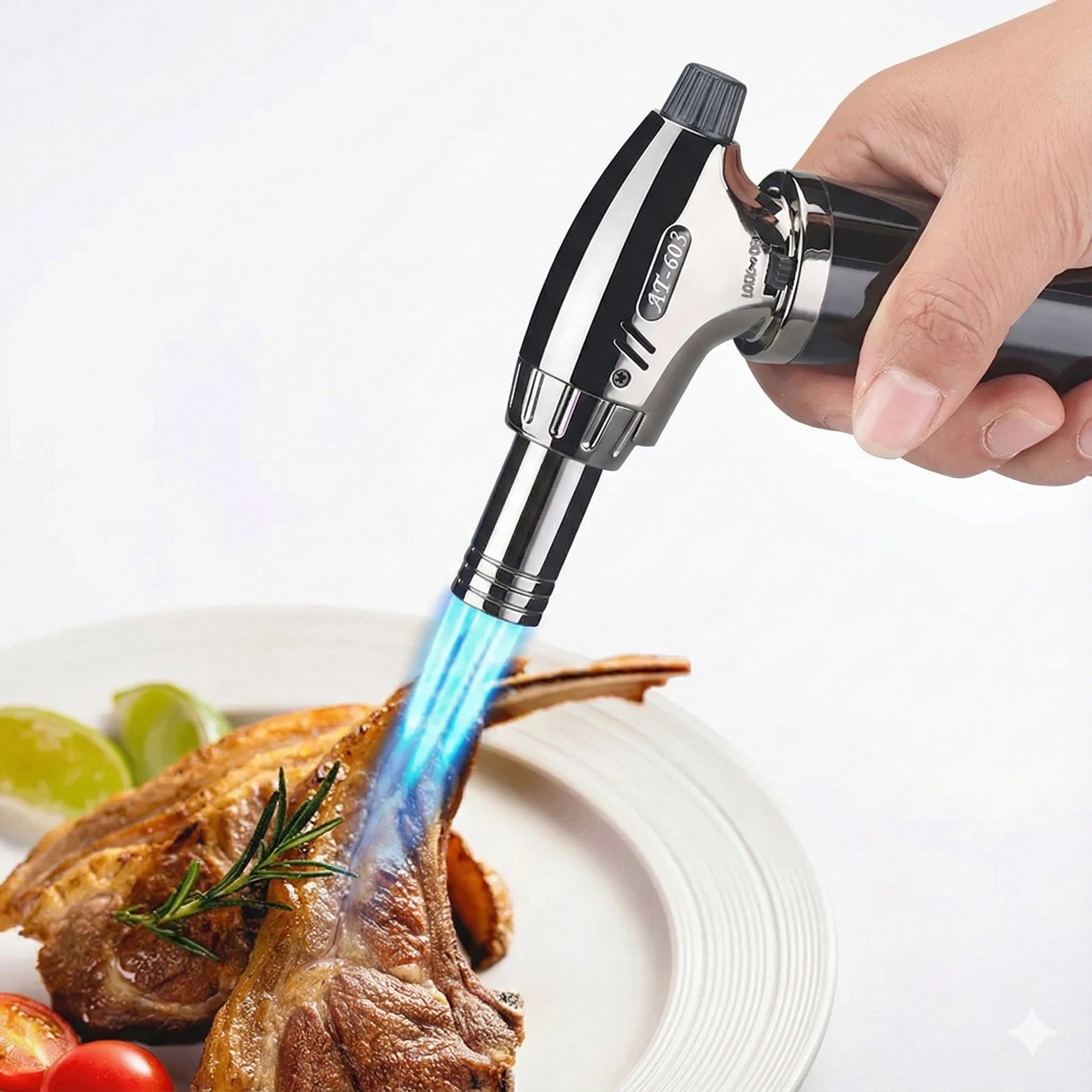 Butane torch being used to cook a piece of meat on a plate with limes and tomatoes.