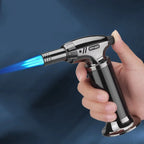 Hand holding a butane torch with blue flame against a dark background