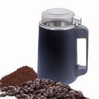 Blue insulated mug with handle, surrounded by coffee beans and ground coffee on a white background