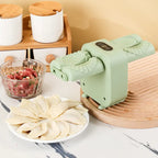 Green pasta maker with fresh pasta on a plate, next to a bowl of uncooked pasta dough.