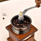 Manual coffee grinder with coffee beans on a light background