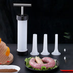 Sausage stuffer with four different sized nozzles on a dark surface.