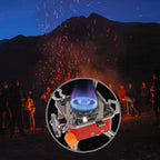 Close-up of a camping stove with people and fireworks in the background