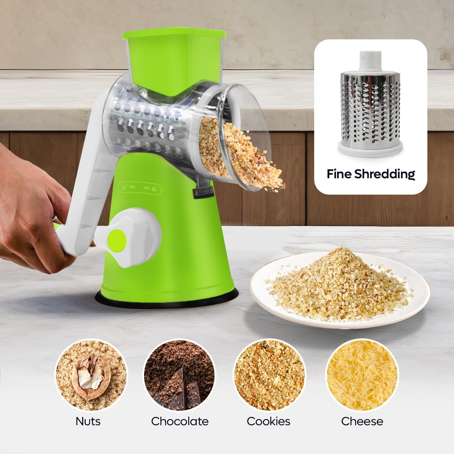 Green manual grater with shredded ingredients on a kitchen counter, showing uses for nuts, chocolate, cookies, and cheese.