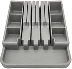 Gray plastic cutlery organizer with multiple compartments on a white background