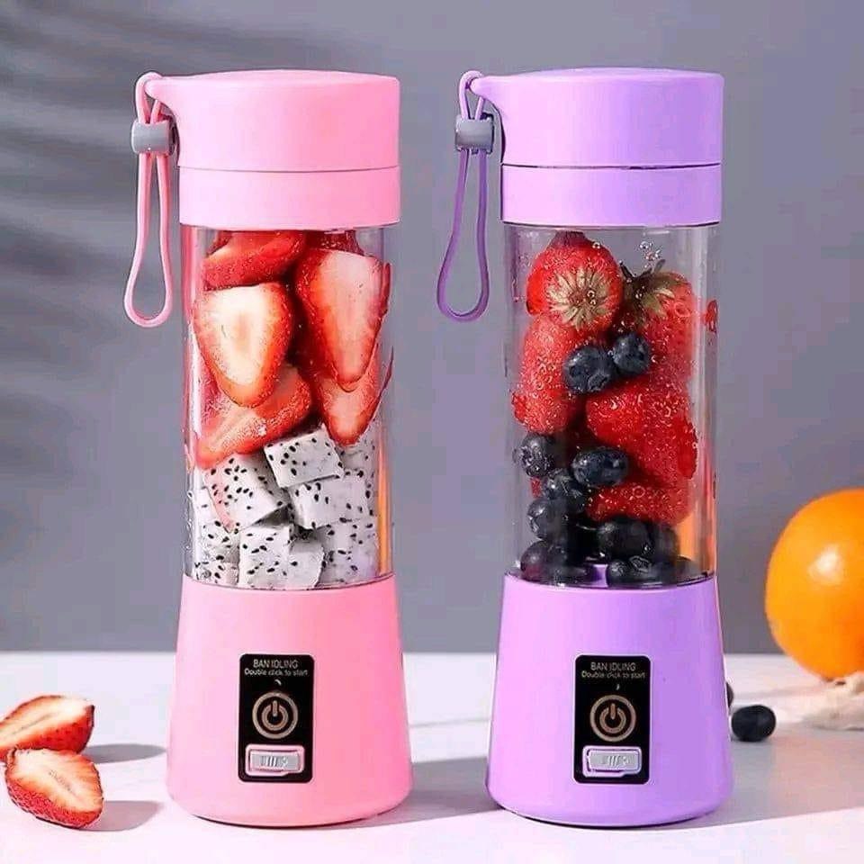 Pink and purple portable blenders with fruits inside on a gray background