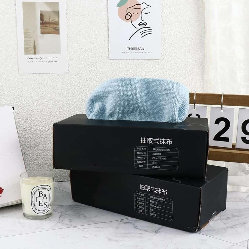 Black boxes with blue towel on a marble surface, candle nearby