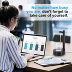 Person working on a laptop with a motivational quote above, featuring a water dispenser and glass on a desk.