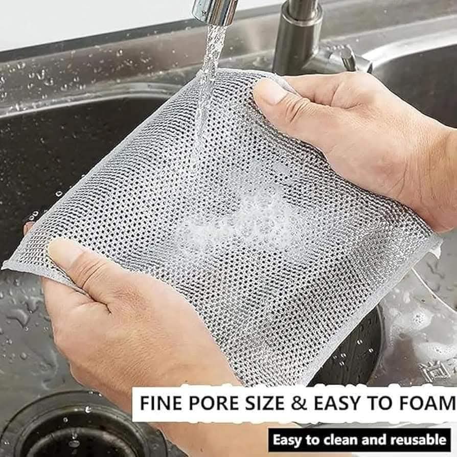 Person holding a mesh scrubber under running water in a sink with text about its features.