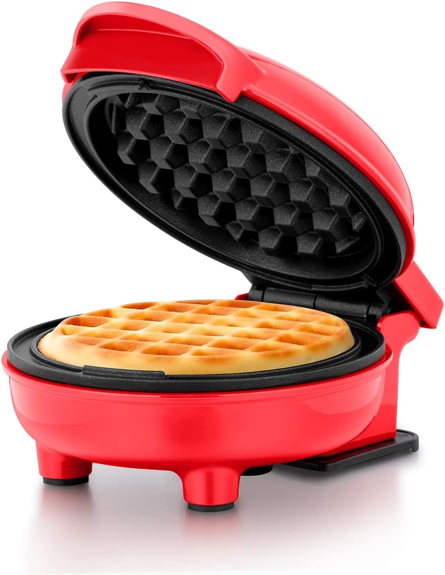 Red waffle maker with a waffle inside on a white background