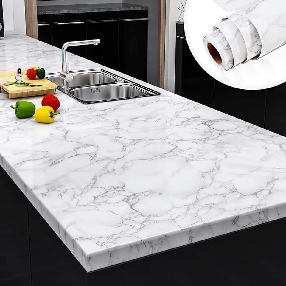 Marble-patterned kitchen countertop with a roll of contact paper.