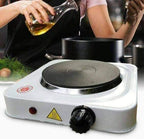 Portable electric hot plate with a person cooking in the background