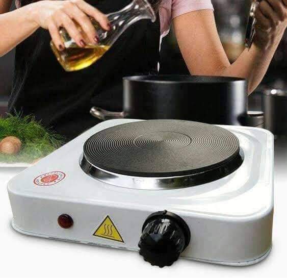 Portable electric hot plate with a person cooking in the background
