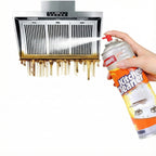 Hand using a kitchen cleaner spray can on a greasy exhaust hood.